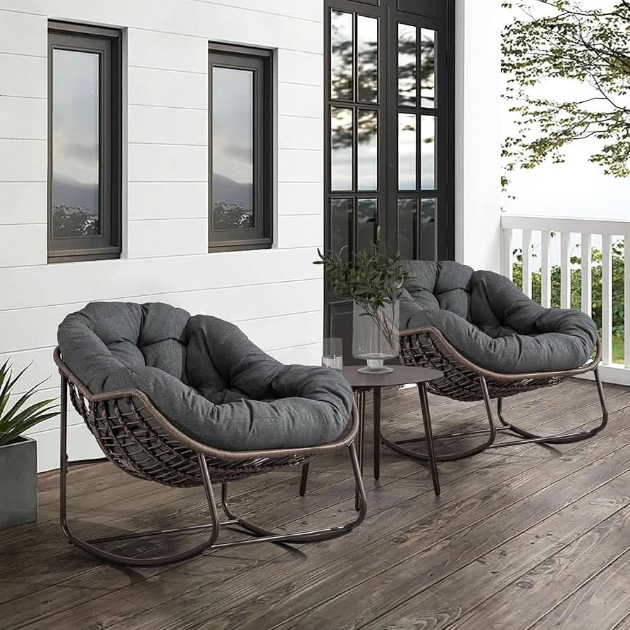två mörk gråa loungestolar på en uteterass, 